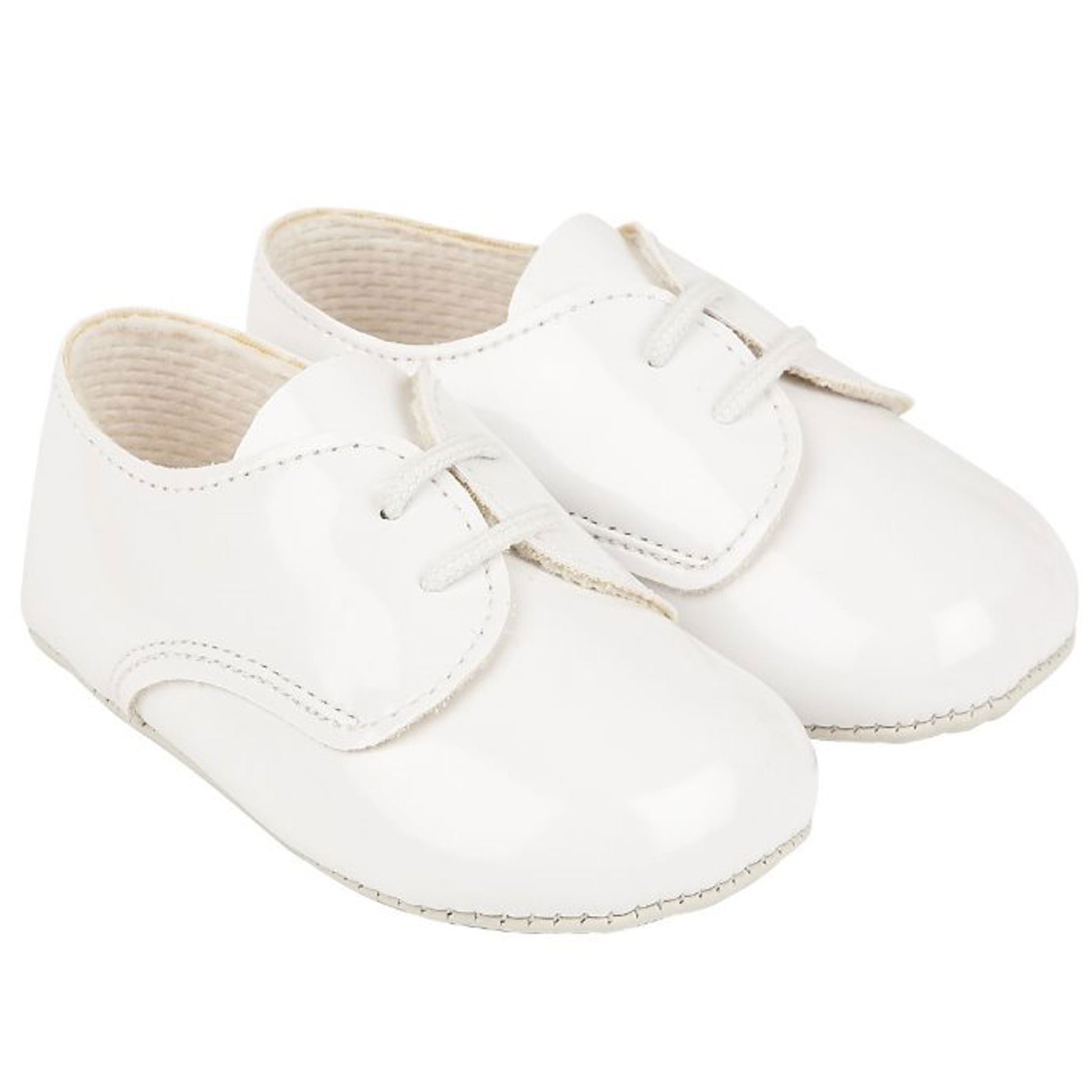 White baby shoes with a bow on a white background