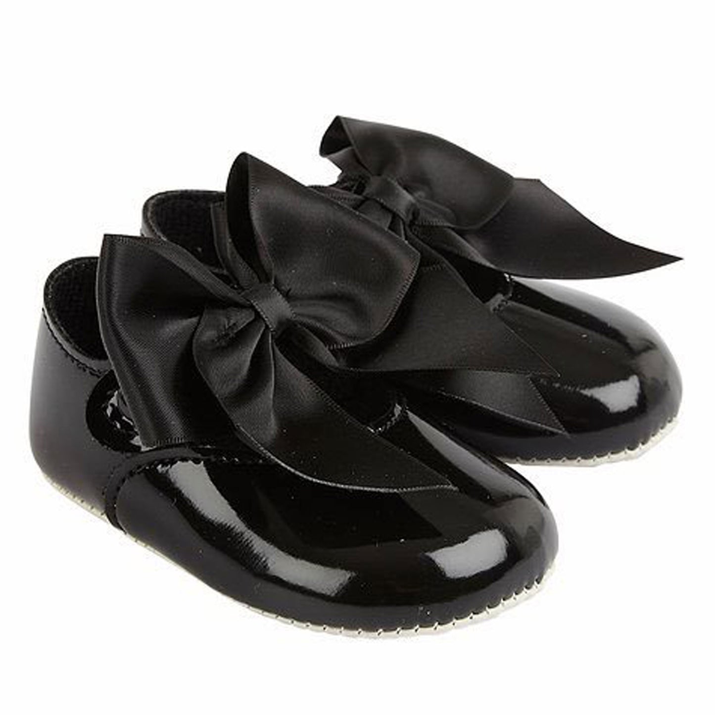 Black patent leather shoes with large bows on a white background