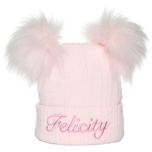 A personalised pastel pink baby hat with double pom poms, embroidered with the name 'Felicity'.