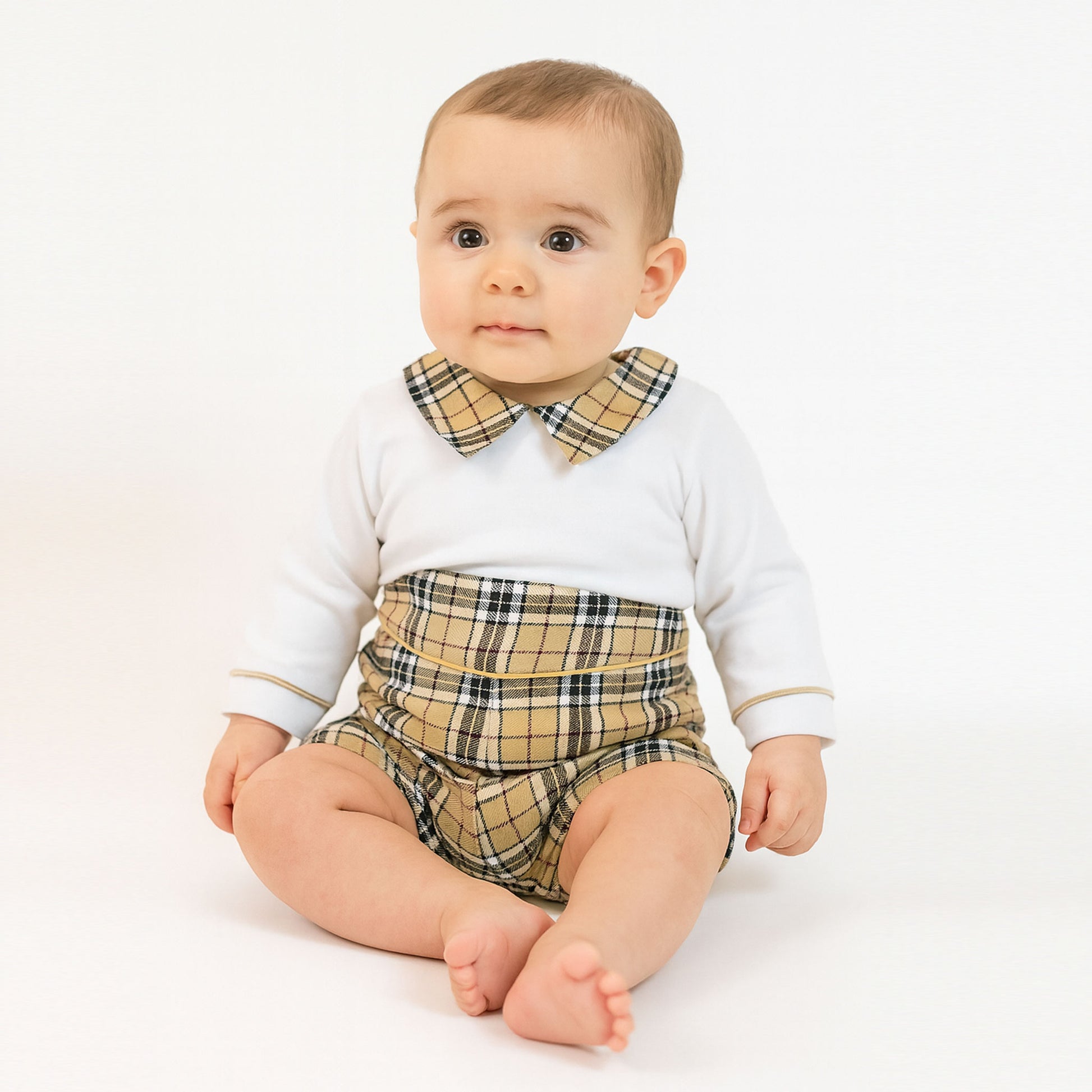 Baby wearing a white long-sleeve shirt with plaid collar and matching plaid diaper on a white background