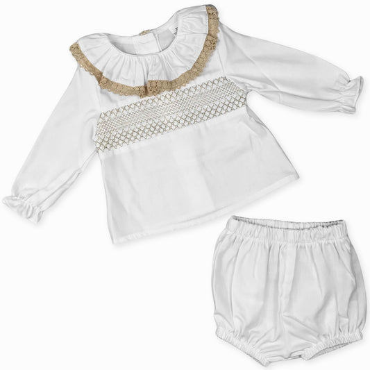 A stylish and cozy baby girl’s white outfit, featuring a lace-trimmed collar and smocked design