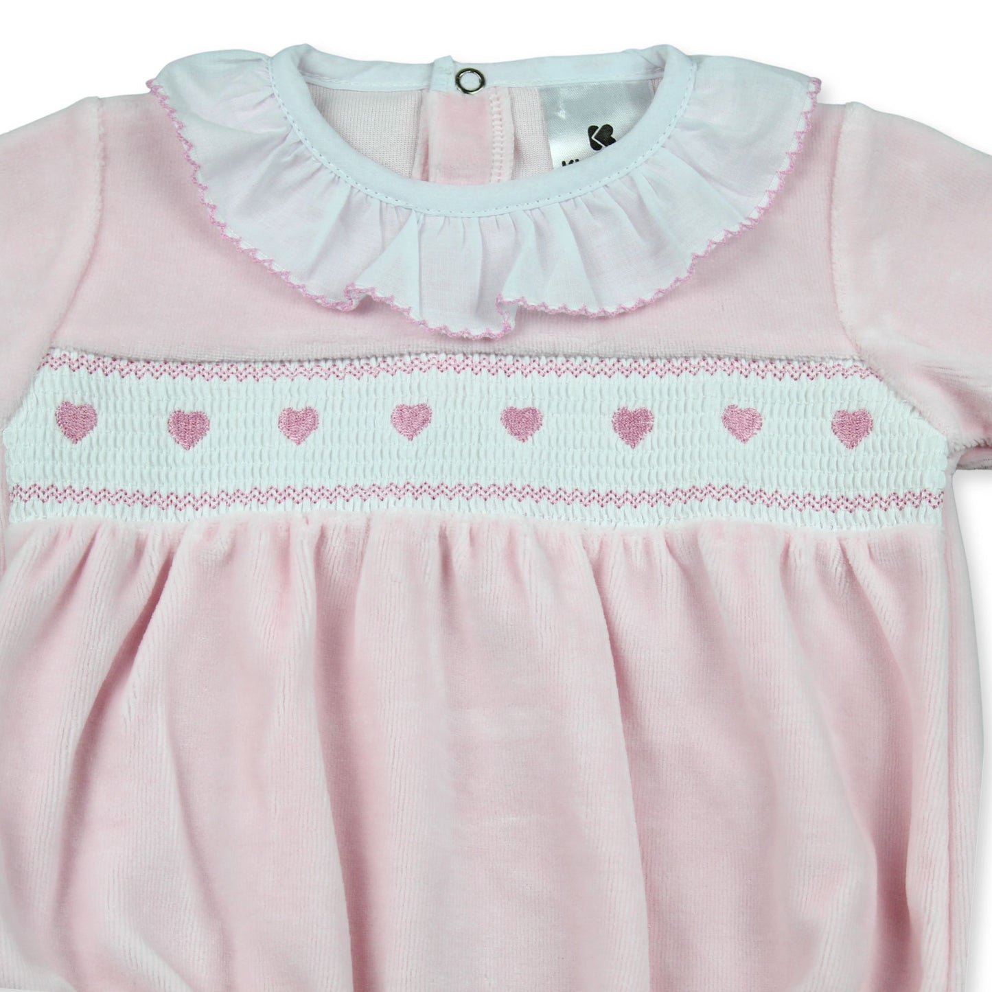 Pink romper with smocked heart details and ruffled collar on a white background