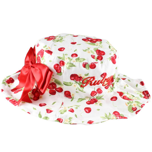 Floral-patterned hat with red cherries and a large red bow on a white background