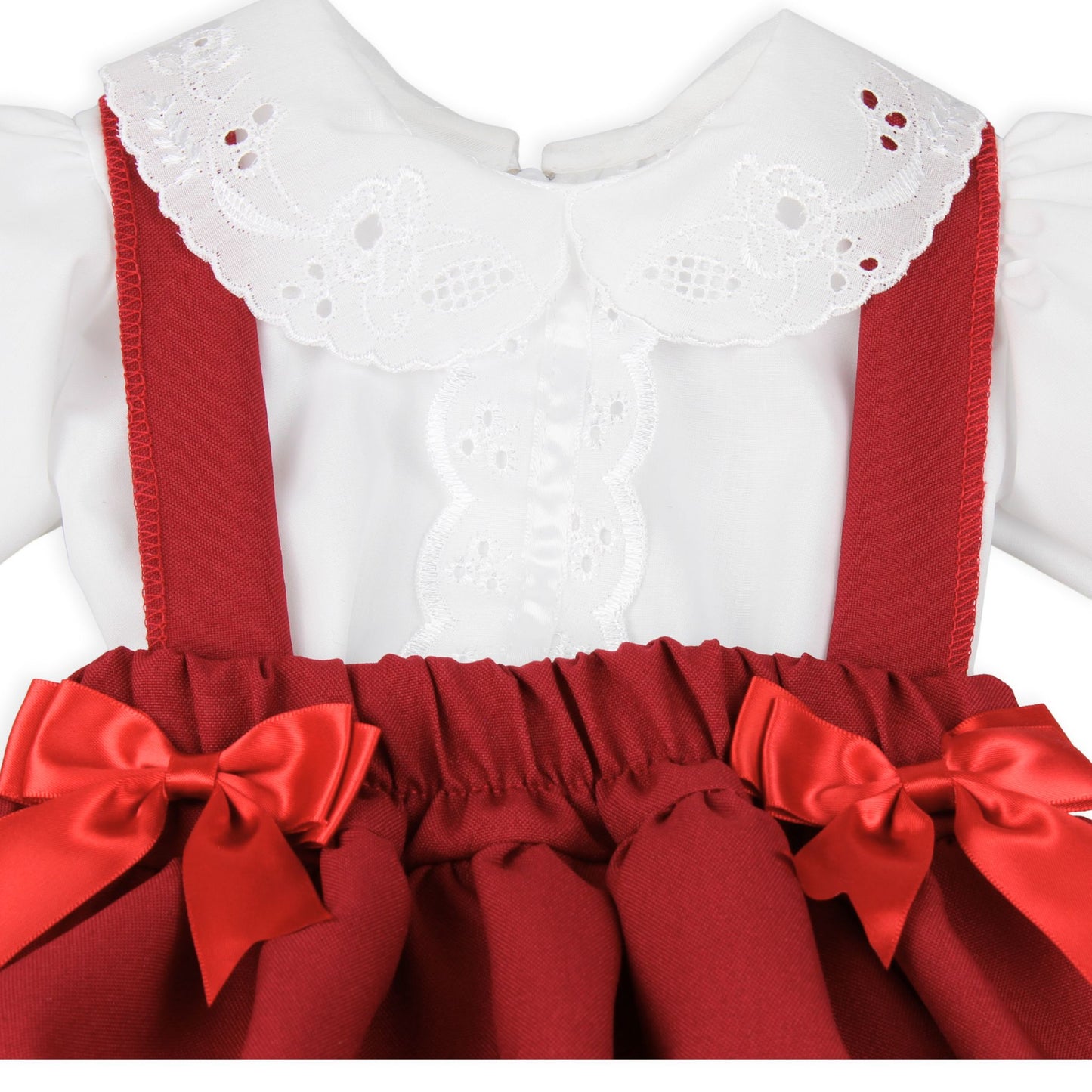 White dress with red suspenders and ribbons on a white background