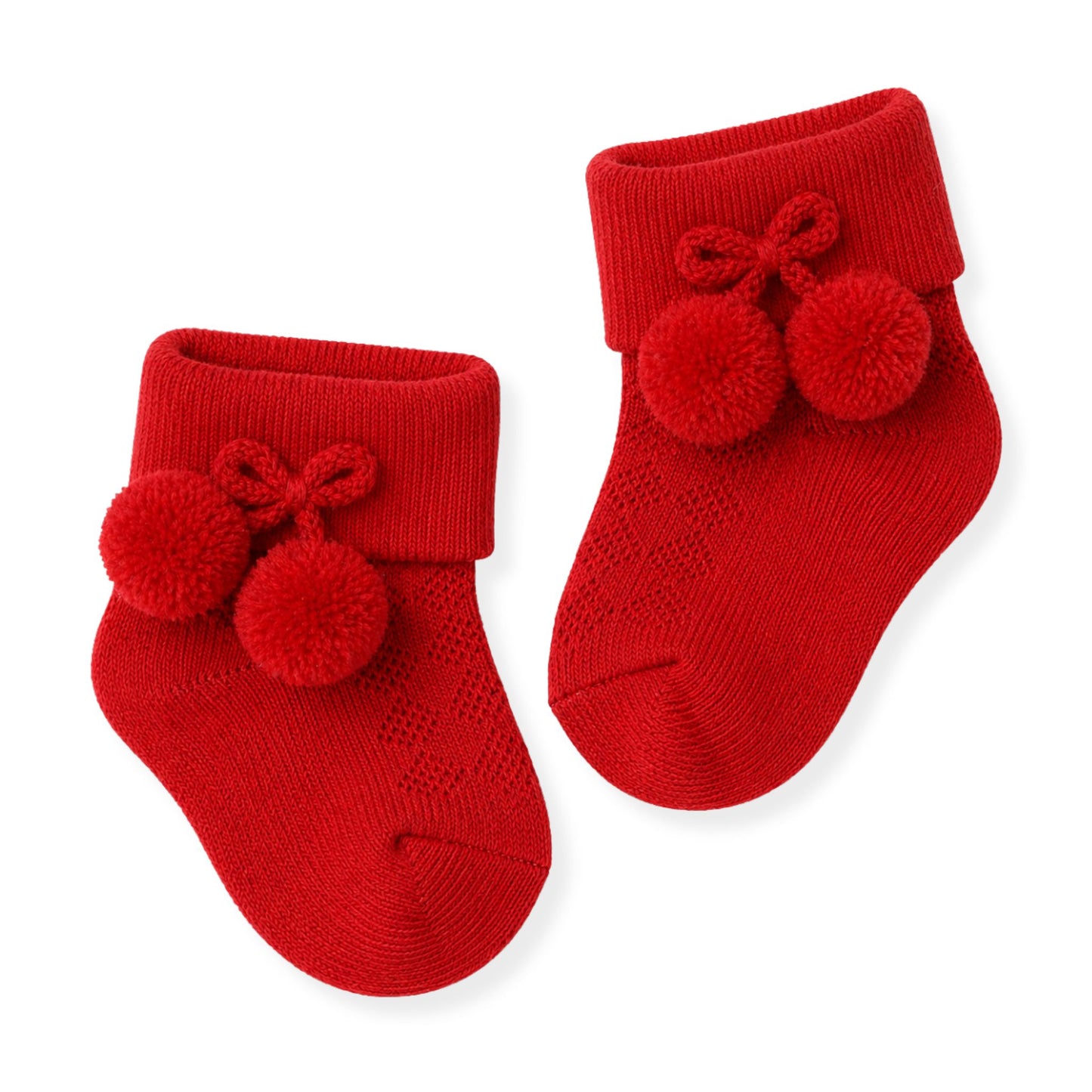 Red baby socks with pom-poms on a white background