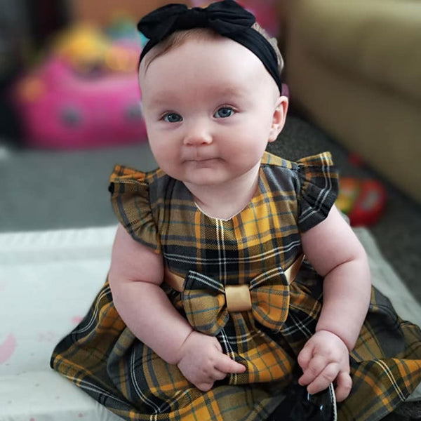 baby girl in a tartan dress