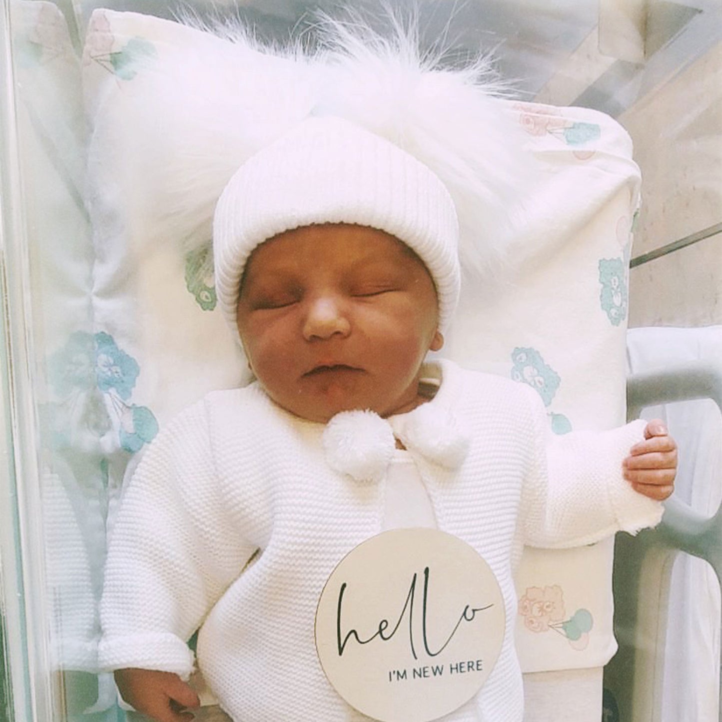 baby hat with fluffy pom poms