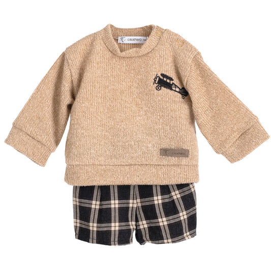 Beige sweater with a small black design and plaid shorts on a white background
