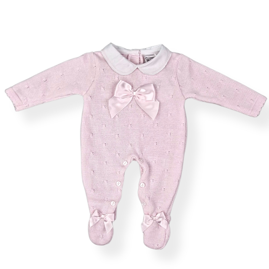 Pink baby onesie with a bow on a white background
