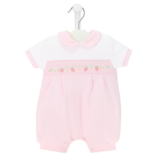 Pink baby romper with white top on a hanger against a white background