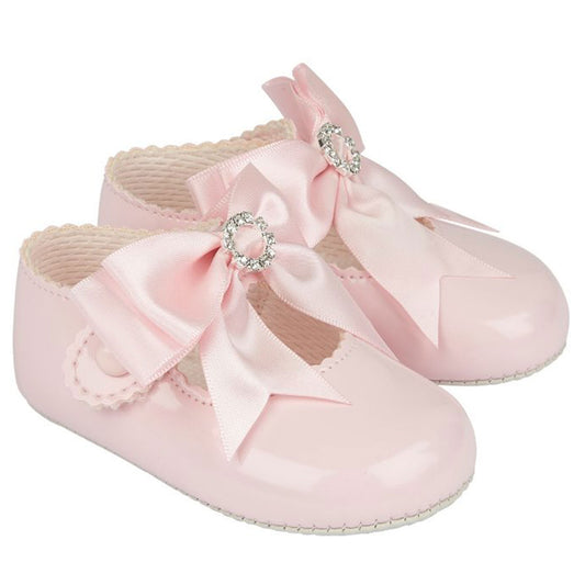 Pink baby shoes with bows and rhinestones on a white background