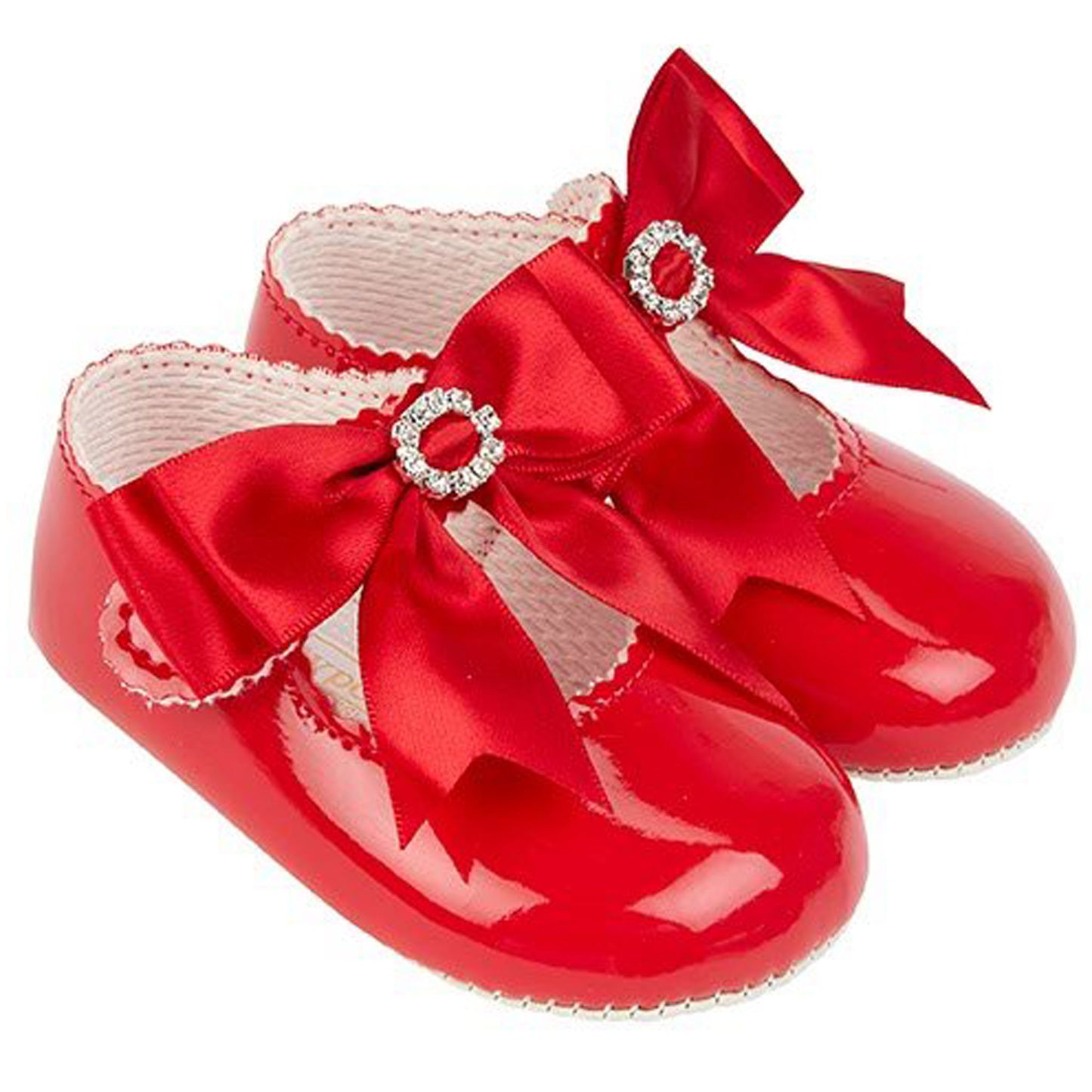 Red baby shoes with satin bows on a white background