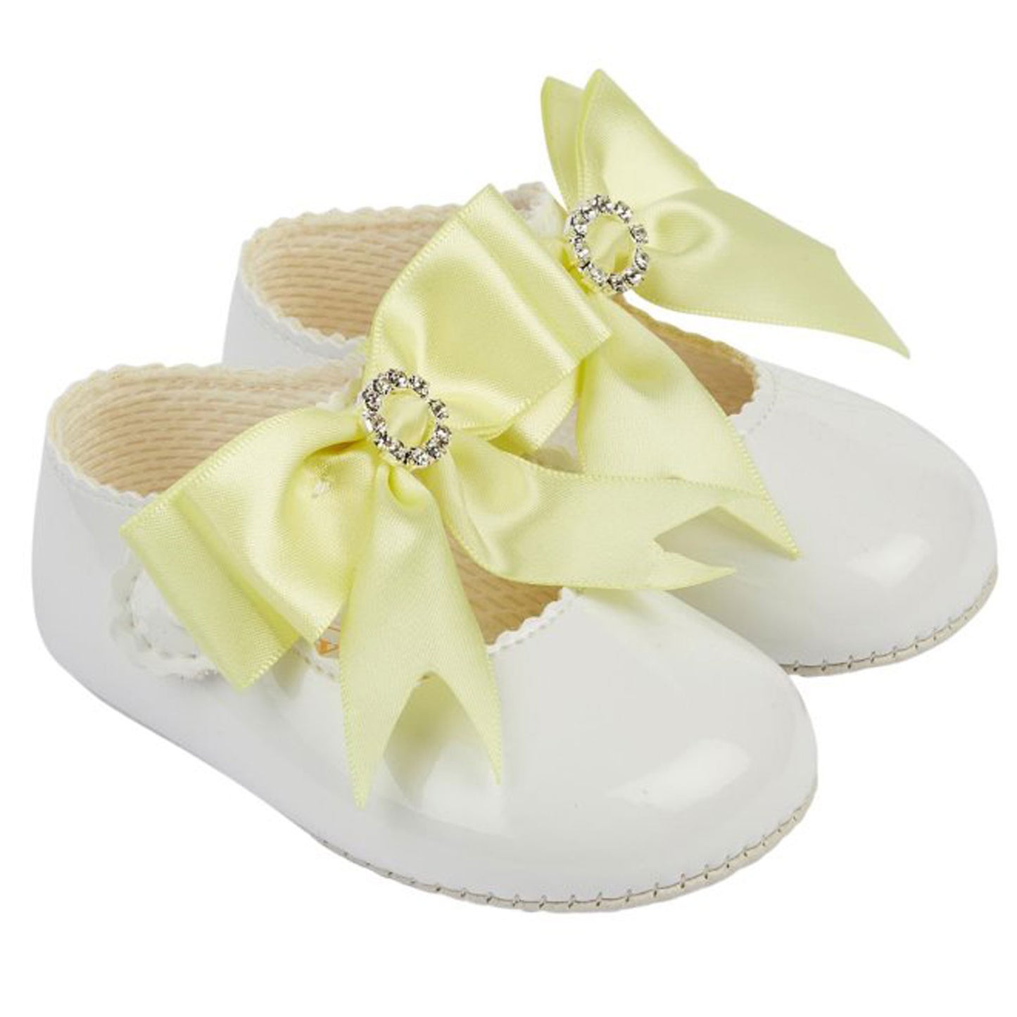 White baby shoes with large yellow bows on a white background