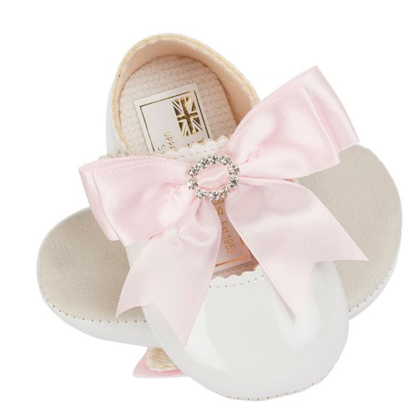 Baby shoes with a large pink bow and rhinestone center on a white background