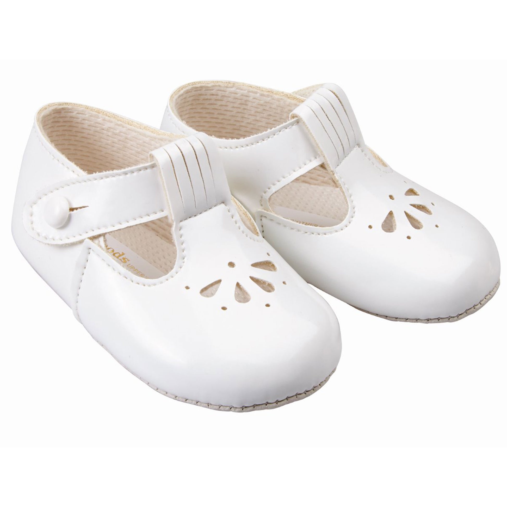 Pair of white baby shoes with cut-out design on a white background
