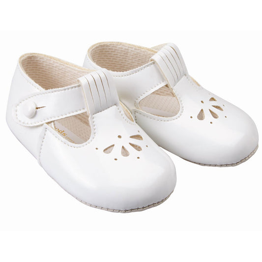 Pair of white baby shoes with cut-out design on a white background