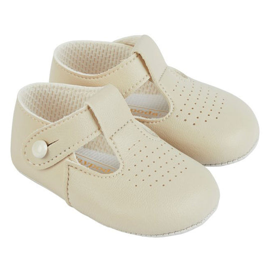 Pair of beige baby shoes with a strap on a white background
