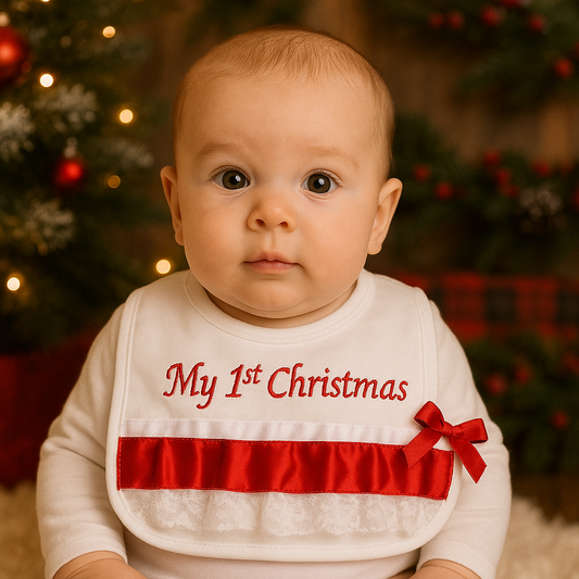 Baby wearing a 'My 1st Christmas' bib in front of a decorated Christmas tree.