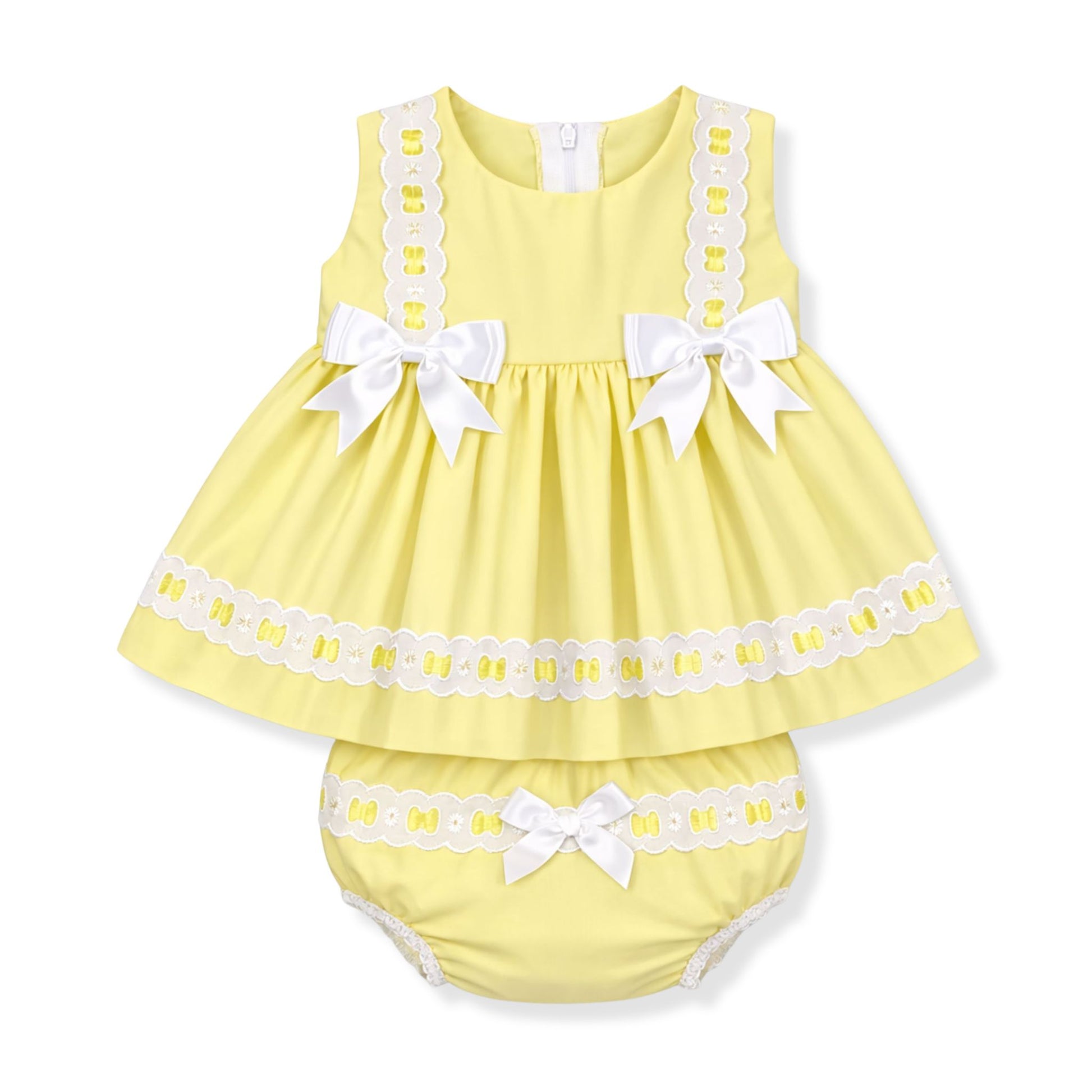 Yellow baby dress with white lace and bows on a white background