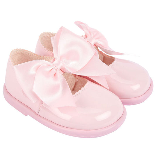 Pink baby shoes with a bow on a white background