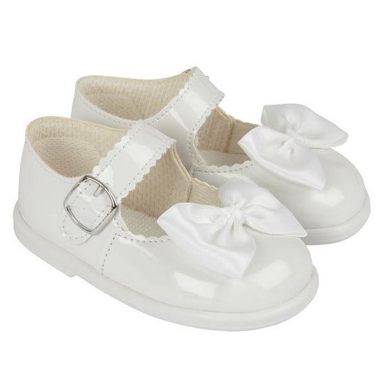 White baby shoes with bows on a white background
