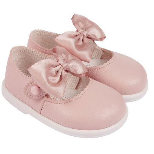 Pink baby shoes with bows on a white background