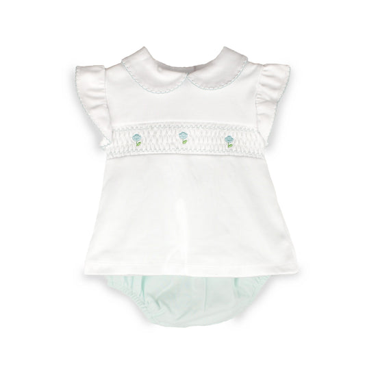 A white baby smocked romper with ruffled sleeves, a Peter Pan collar, and a smocked chest band decorated with three small light blue and green floral motifs, shown on a plain white background.