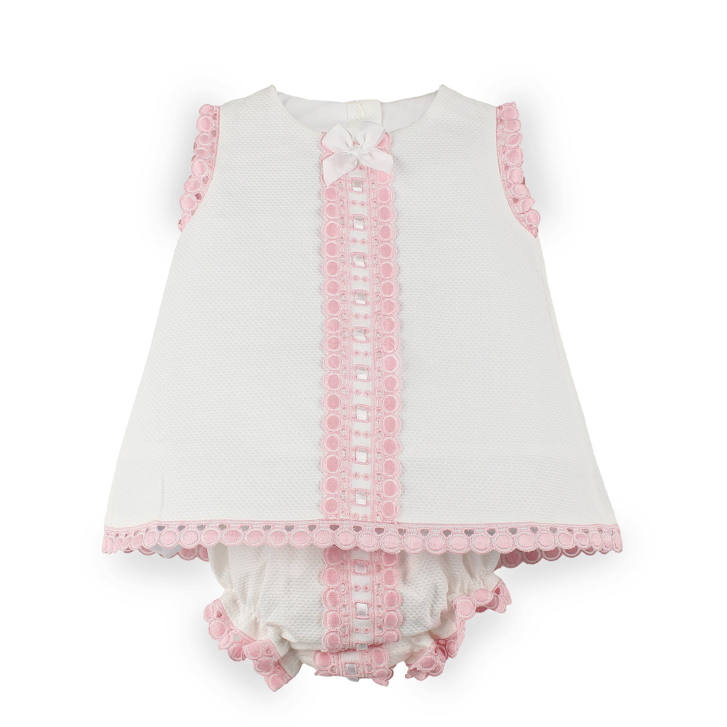 A baby girl's sleeveless white dress with pink lace trim, a matching pink lace front panel, a white bow at the neckline, and matching ruffled bloomers.