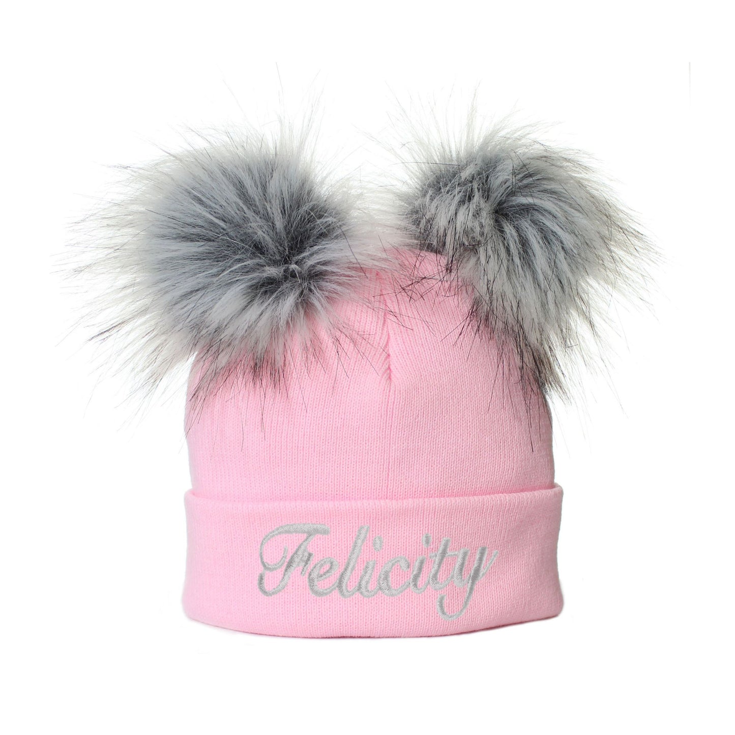 Pink beanie with two large fur pom-poms and 'Felicity' embroidery on a white background