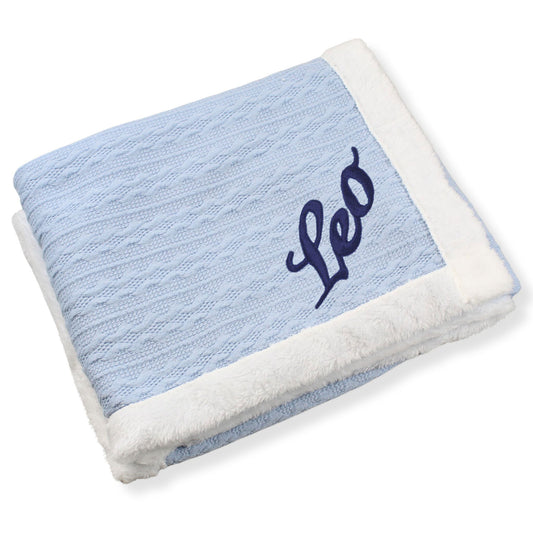 Blue blanket with white border and 'Leo' embroidery on a white background