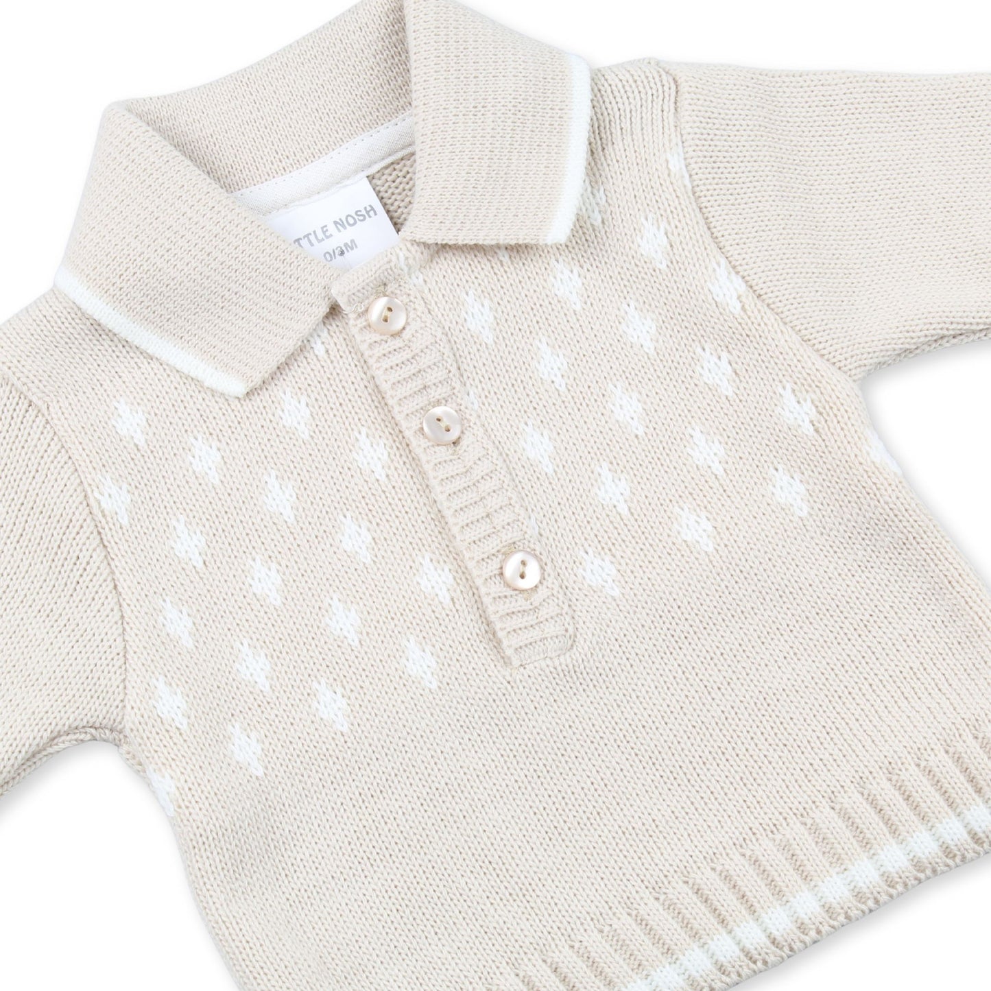 Beige knitted sweater with white polka dots on a white background