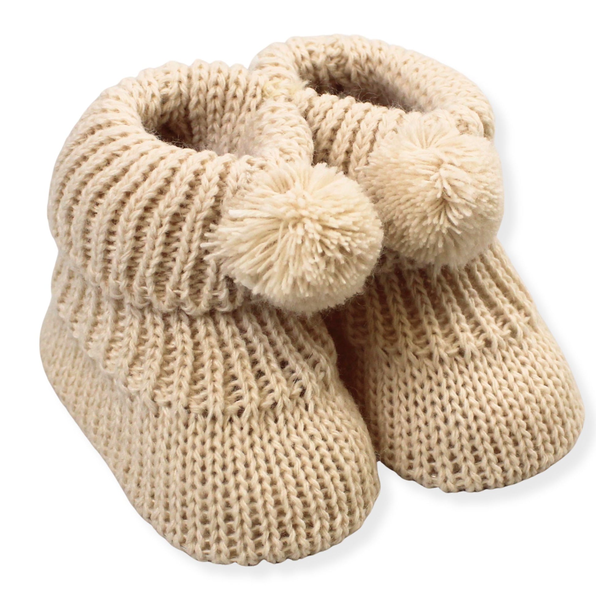 Pair of beige knitted baby booties with pom-poms on a white background