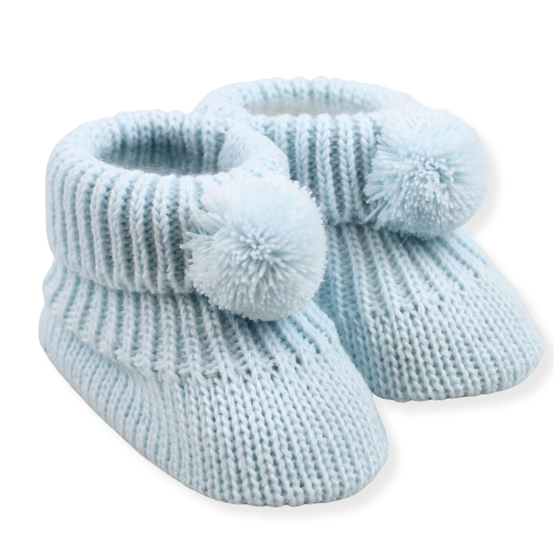 Pair of light blue knitted baby booties with pom-poms on a white background