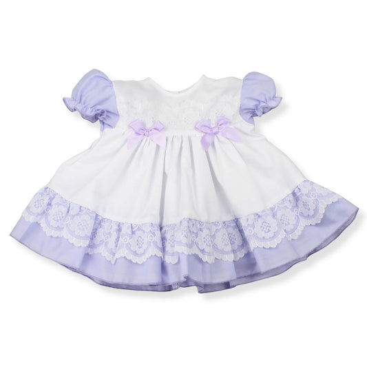 White dress with purple accents and lace details on a white background