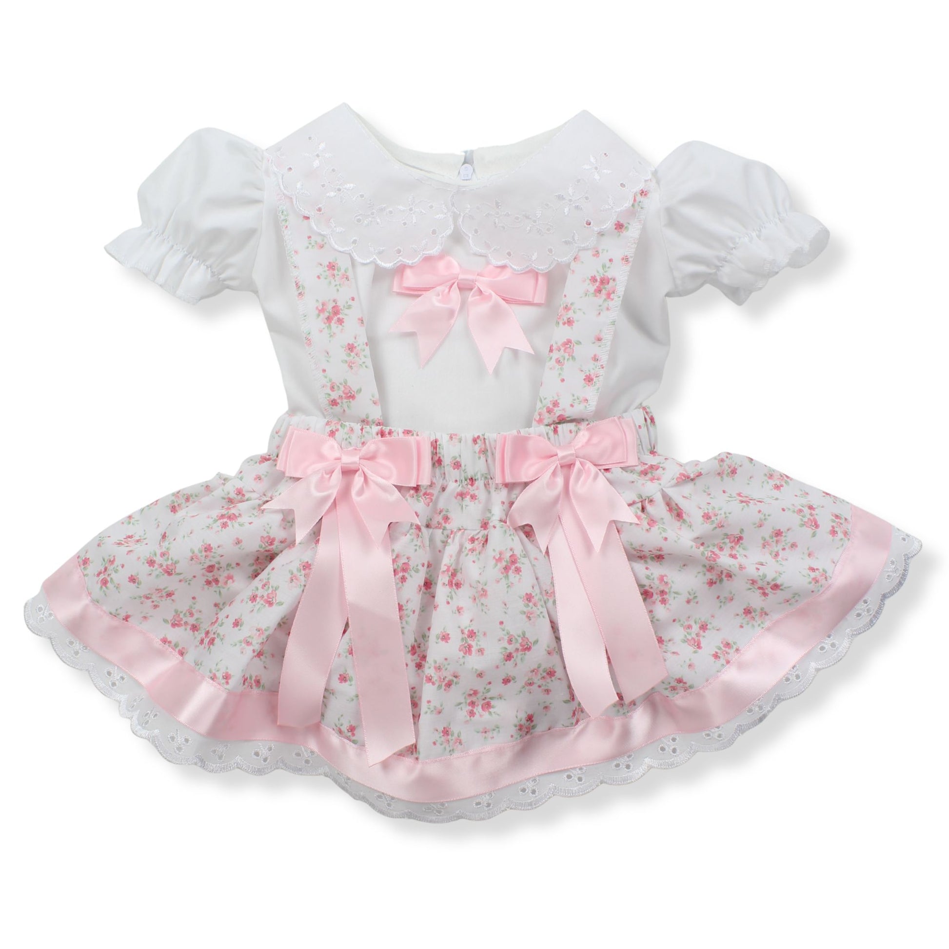 White dress with pink floral pattern and ribbons on a white background