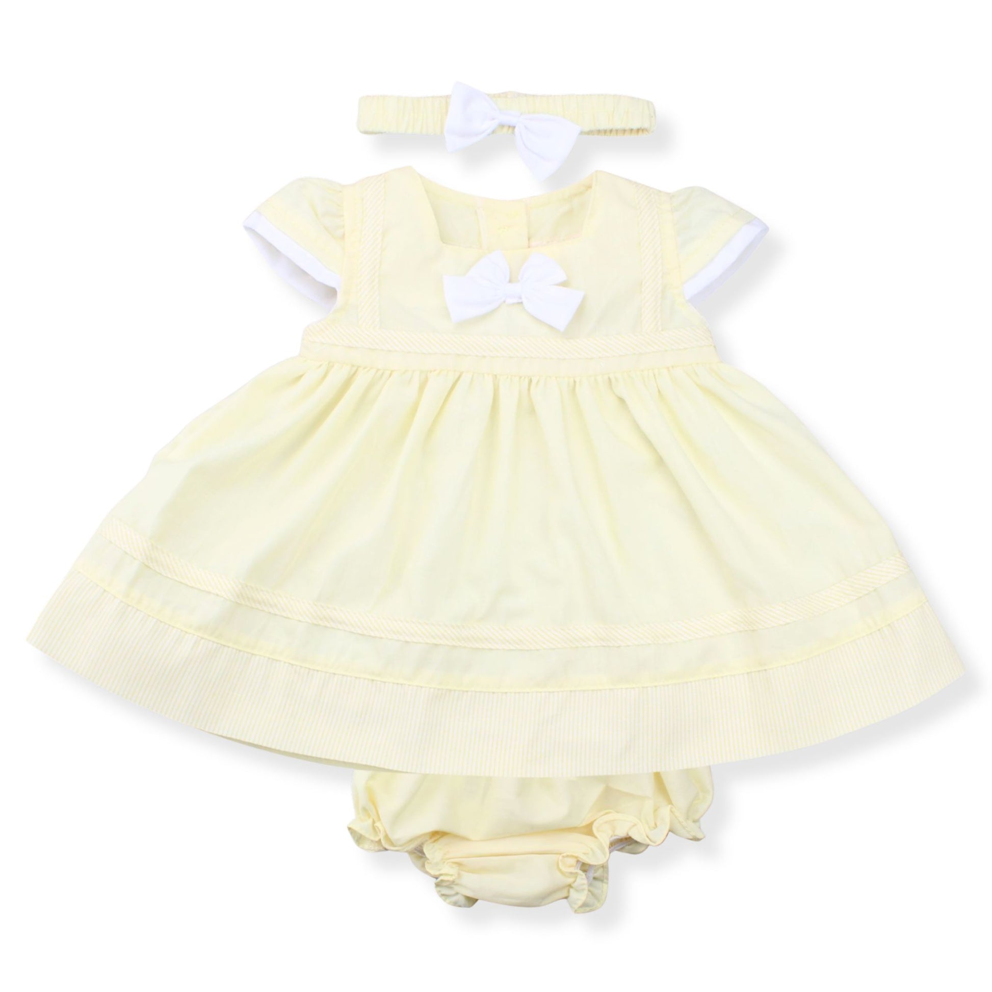 Yellow baby dress with white bow and matching bloomers on a white background