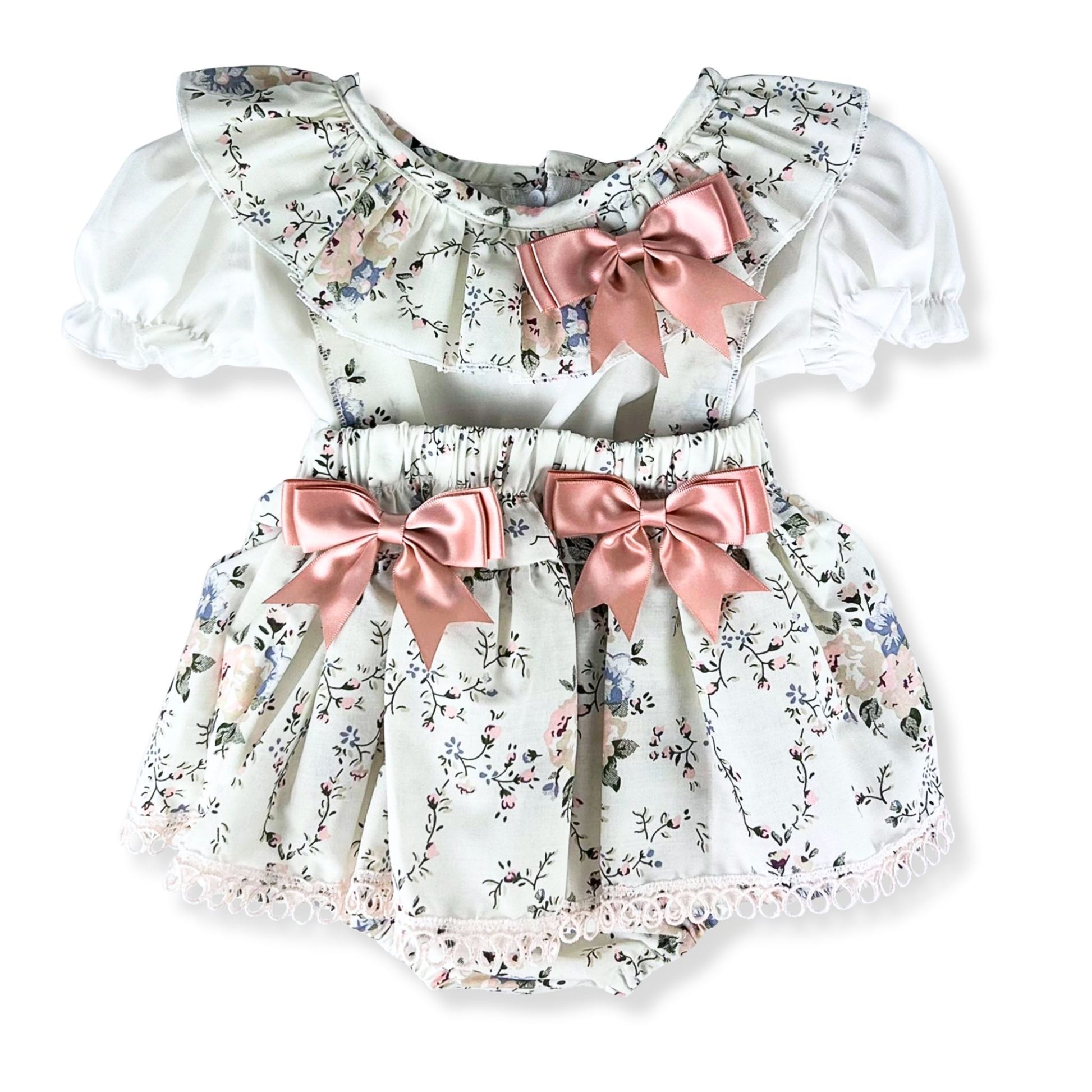 Floral baby dress with pink bows on a white background