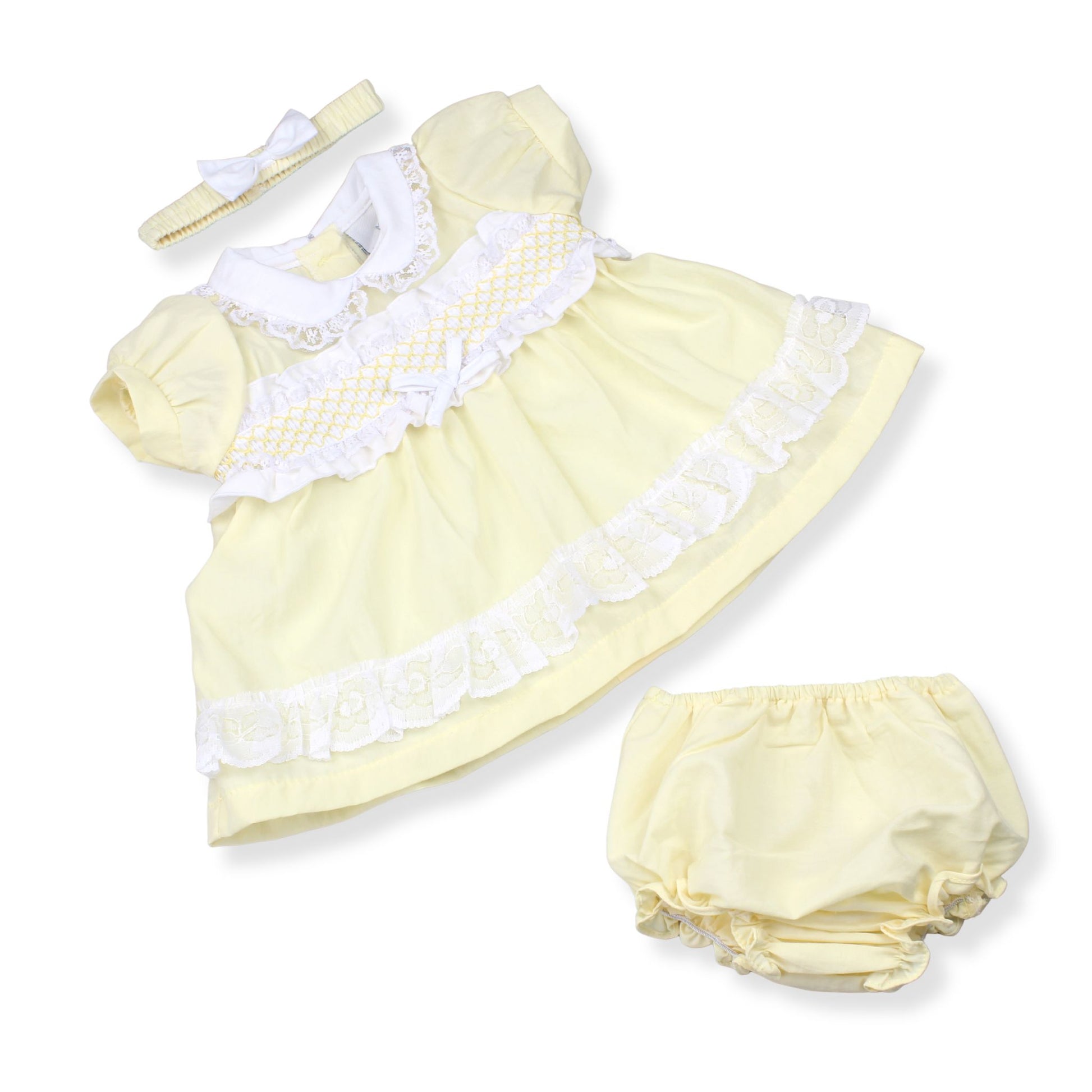 Yellow baby dress with white ruffles and matching bloomers on a white background