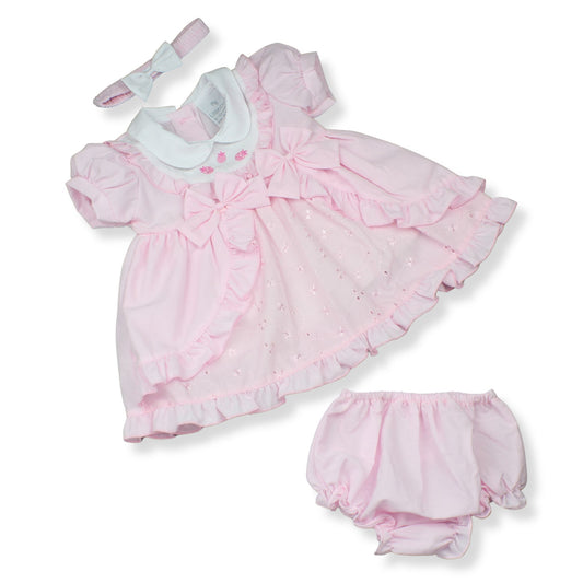 Pink baby dress with ruffles and matching bloomers on a white background
