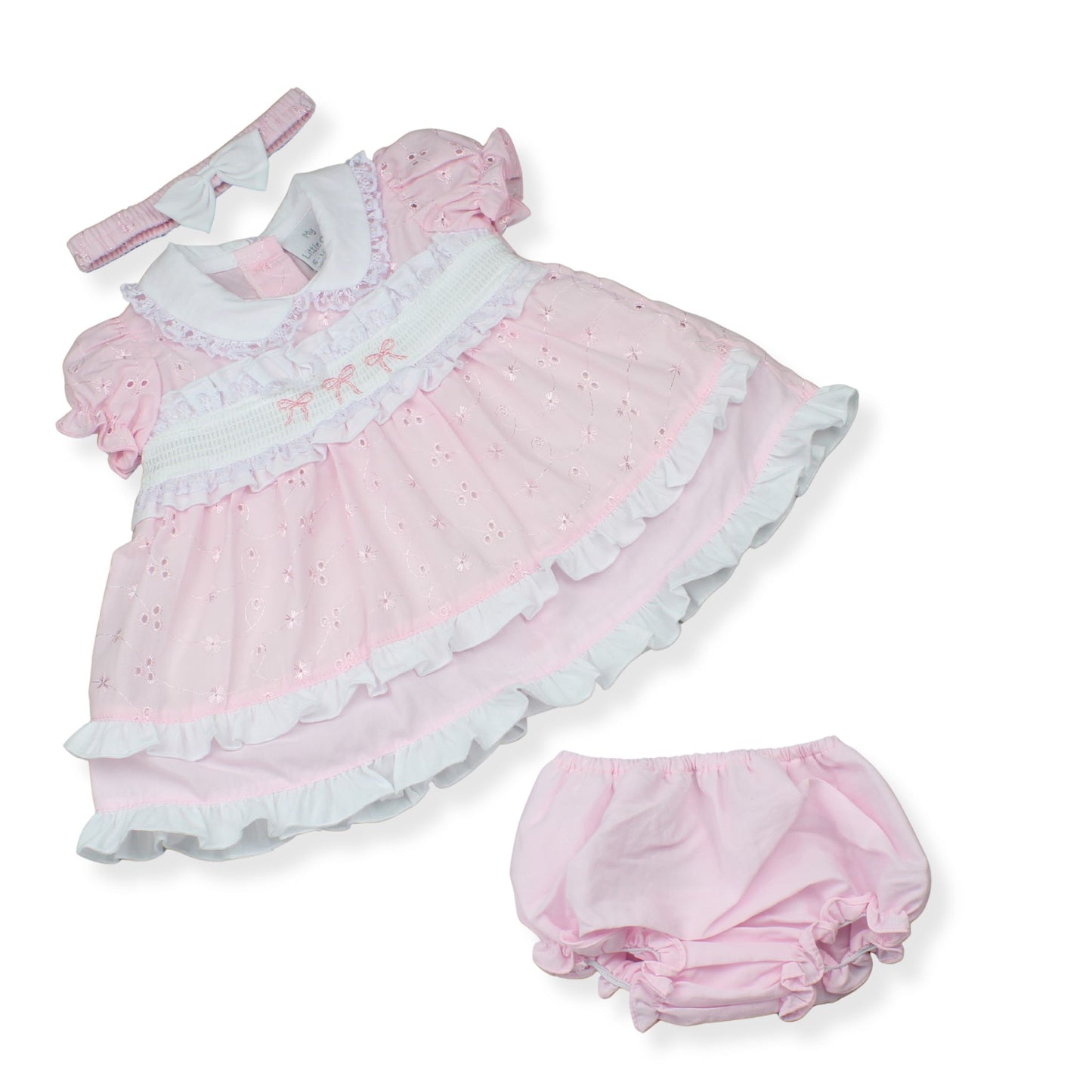 Pink baby dress with ruffles and matching bloomers on a white background