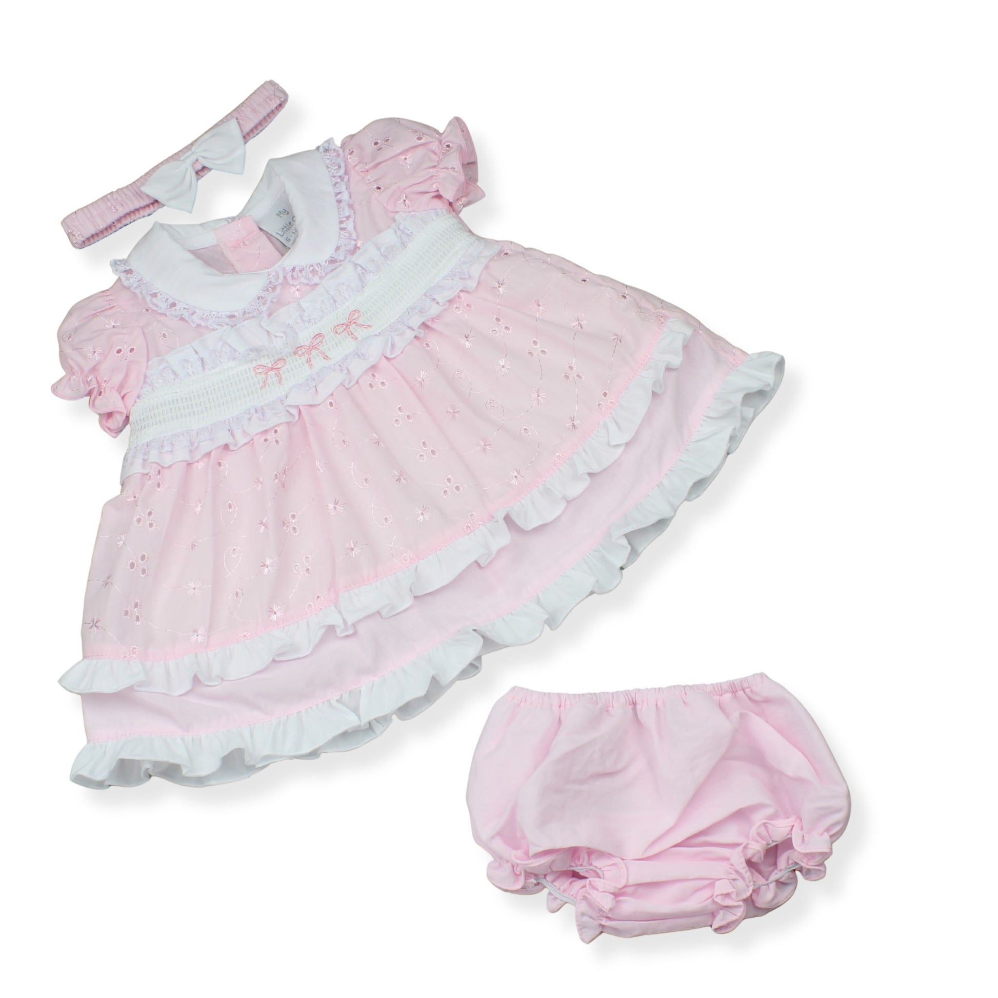 Pink baby dress with ruffles and matching bloomers on a white background