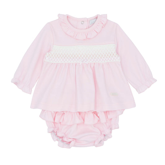 Pink baby romper with ruffled details on a white background