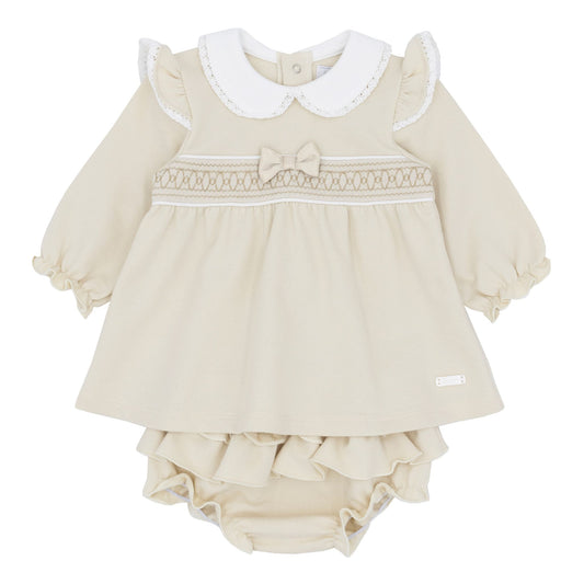 Beige baby dress with white collar and ruffles on a white background
