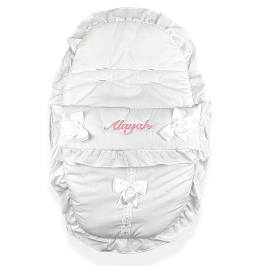 White baby carrier with ruffles and bows on a white background