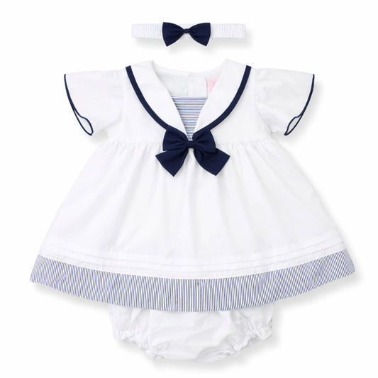 Baby sailor outfit with dress, bloomers, and headband on a white background