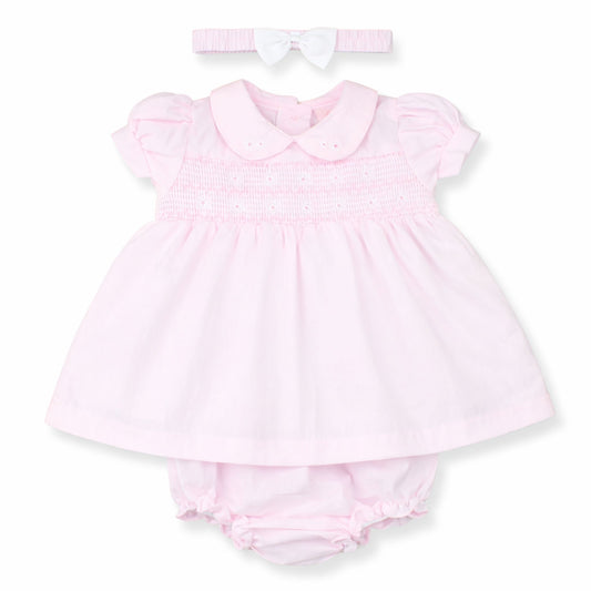 Pink baby dress with matching bloomers and headband on a white background
