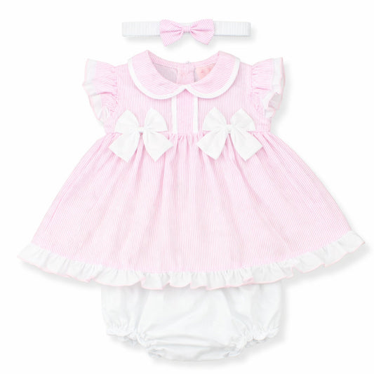 Pink baby dress with white ruffles and matching headband on a white background