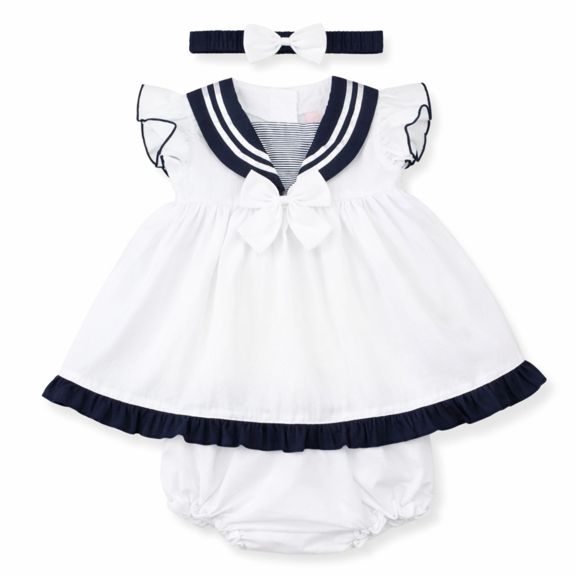 White baby dress with navy trim and matching headband on a white background