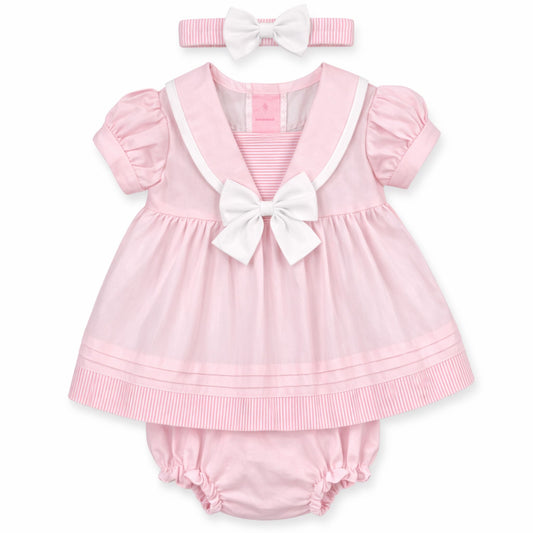 Pink baby dress with white trim and bow, accompanied by a matching headband on a white background.