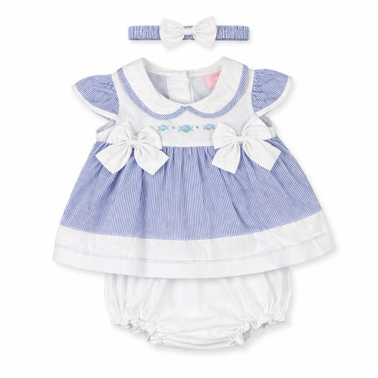 Baby dress with ruffles, bows, and matching headband on a white background